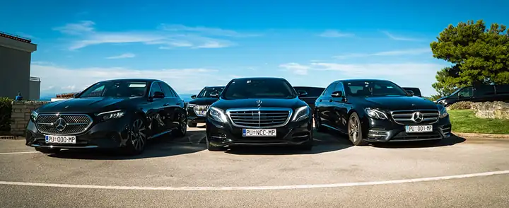 Black Mercedes E-Class and S-Class cars of Taxi Transfers Umag parked by the sea